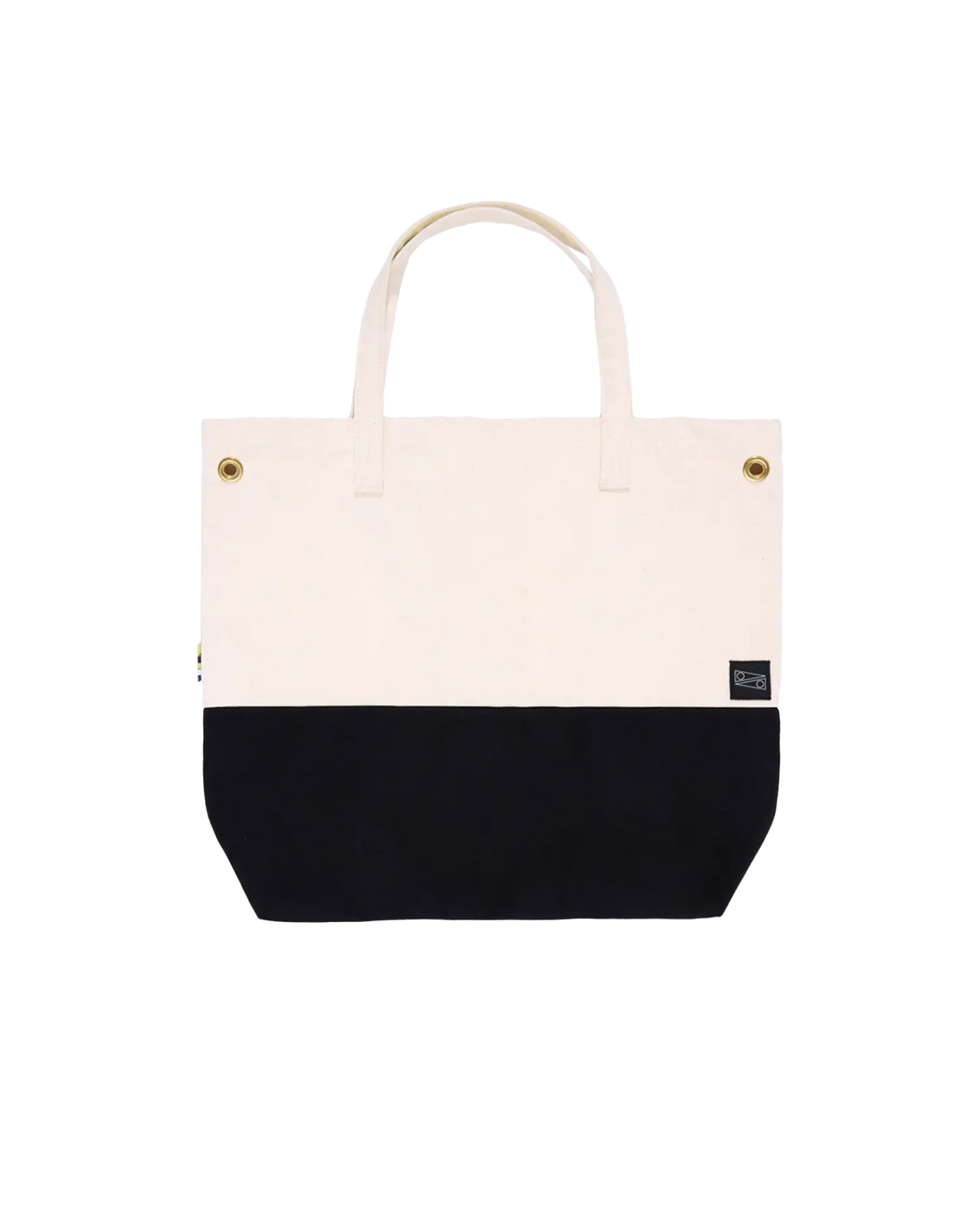 A canvas tote bag with a black bottom and white top, with brass clip closures and a small brand tag visible.