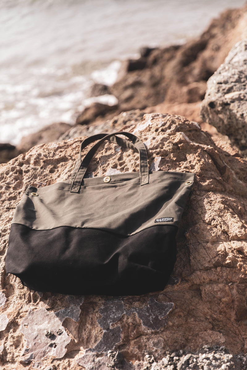 luxury surf tote on rocks by ocean